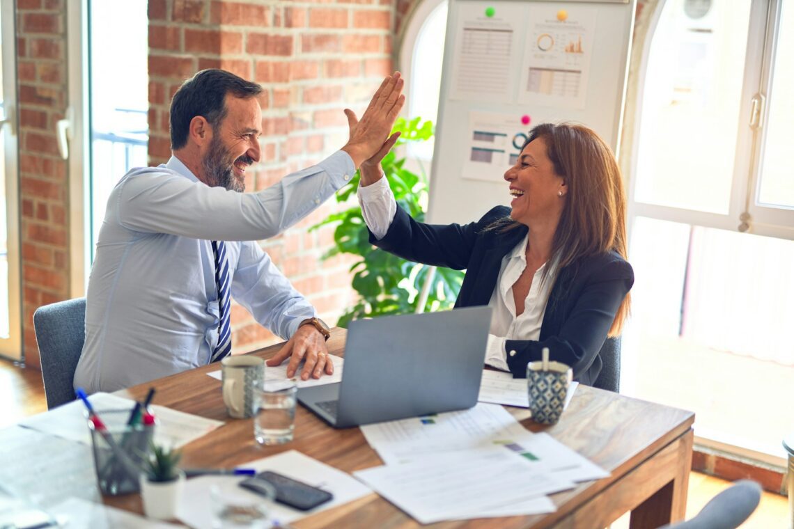 Two people at work giving high five